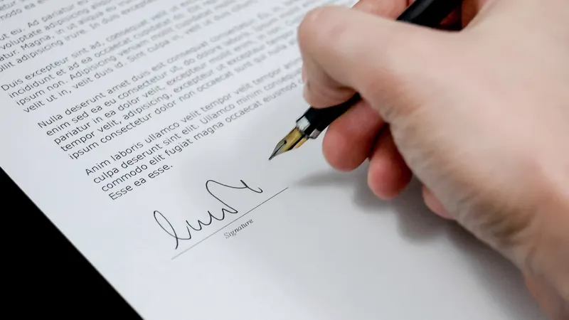 Mano firmando un documento